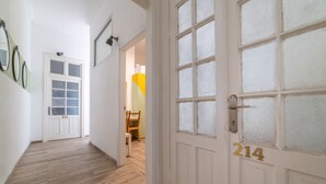 A hallway with wooden flooring, white walls, and a door marked with the number 214. - Paamonim Studios - Adults only (Jerusalem)