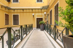 A corridor with a metal railing, potted plants, and a door labeled "KALAM". - Colosseo Green Park – Home and More (Rome)