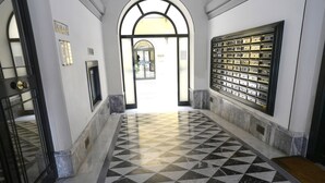 Un couloir doté d’un sol à carreaux, d’une porte noire et blanche et d’une vitrine fixée au mur.