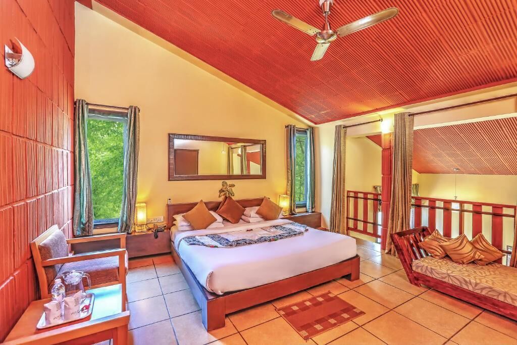Un dormitorio espacioso con una cama grande, una zona de estar y un balcón.