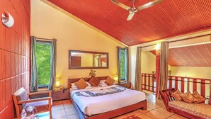 Un dormitorio espacioso con una cama grande, una zona de estar y un balcón.