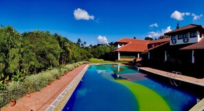 Una piscina al aire libre, sillones reclinables de piscina