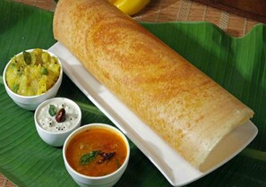 Een traditionele Zuid-Indiase maaltijd met een dosa, kokosnoot chutney, sambar en raita.