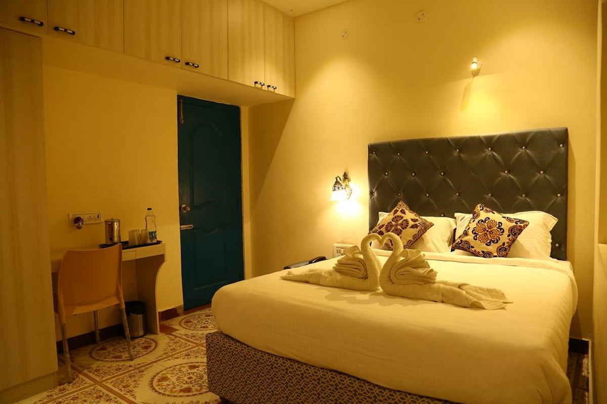 Una habitación de hotel con cama, escritorio y puerta.