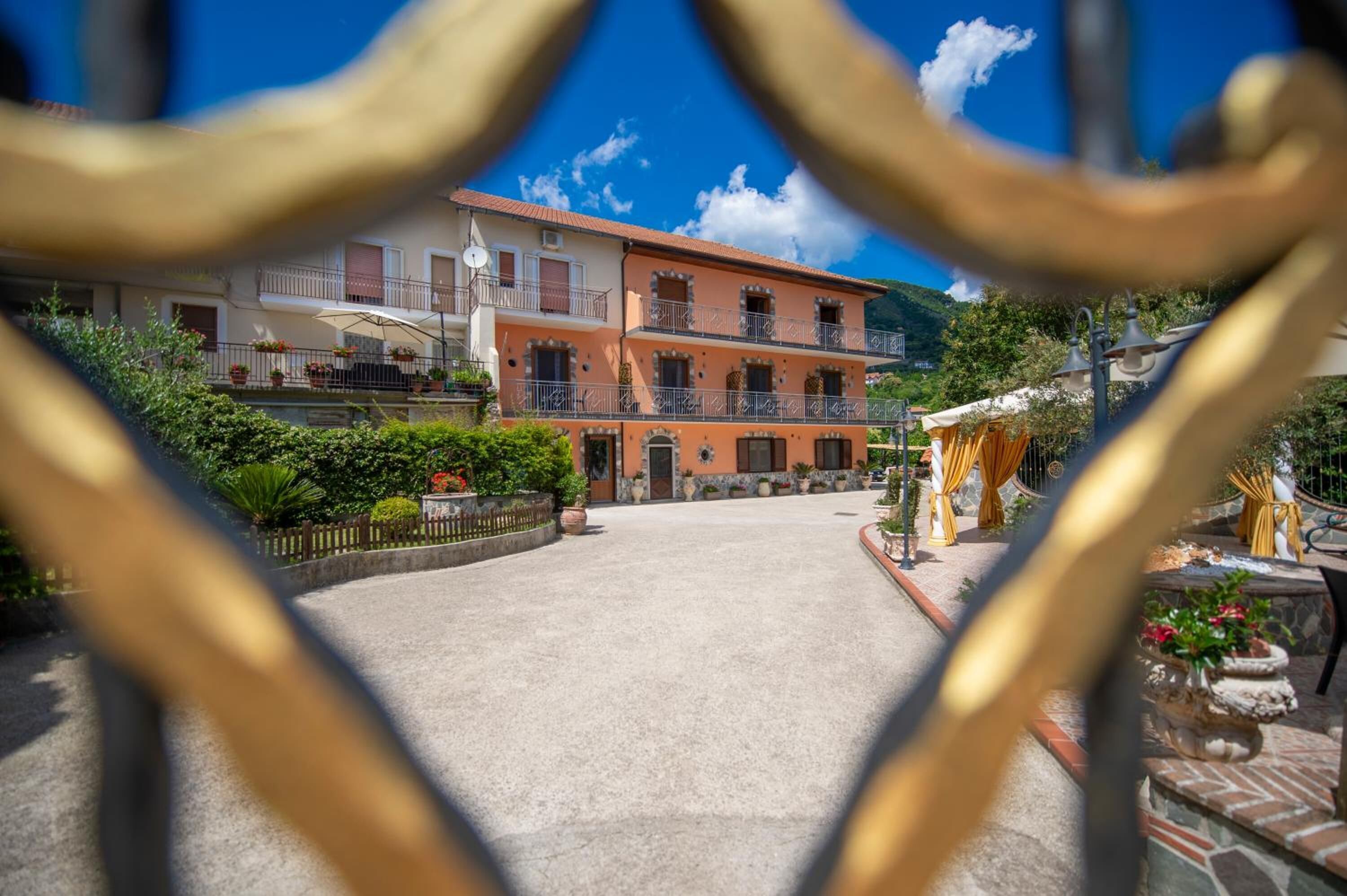 A courtyard with a building featuring a balcony and a clock.