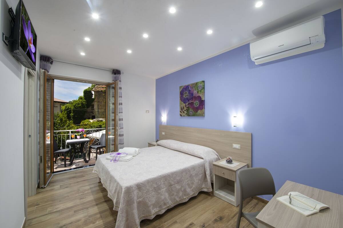 Une chambre à coucher avec un lit, un bureau, une chaise et une fenêtre.