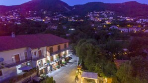A two-story building with a courtyard, surrounded by trees and a mountainous backdrop. - B&B Il Girasole (Agerola)