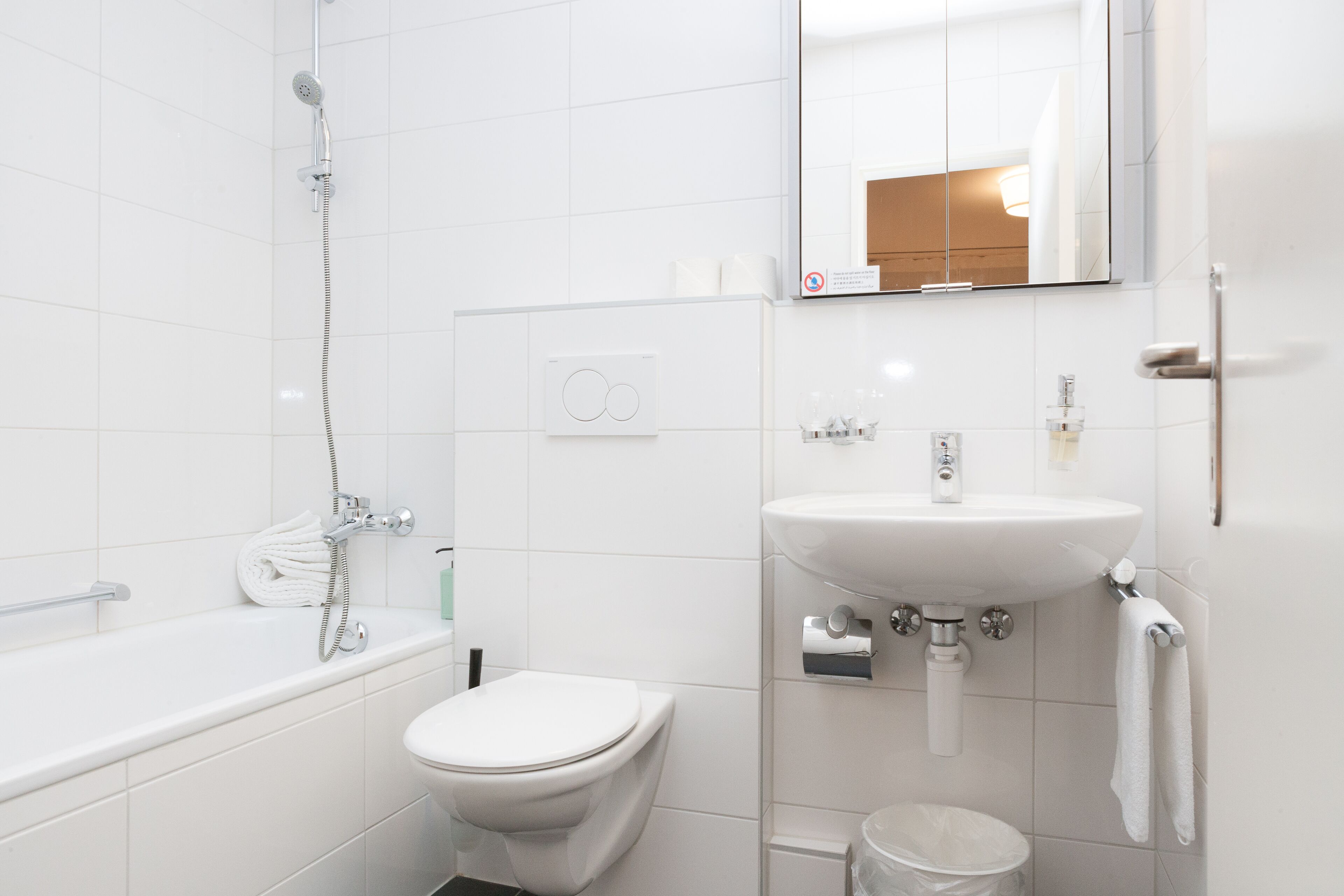 Ein modernes Badezimmer mit Badewanne, Toilette und Waschbecken.