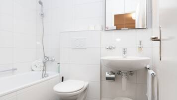 Ein modernes Badezimmer mit Badewanne, Toilette und Waschbecken.