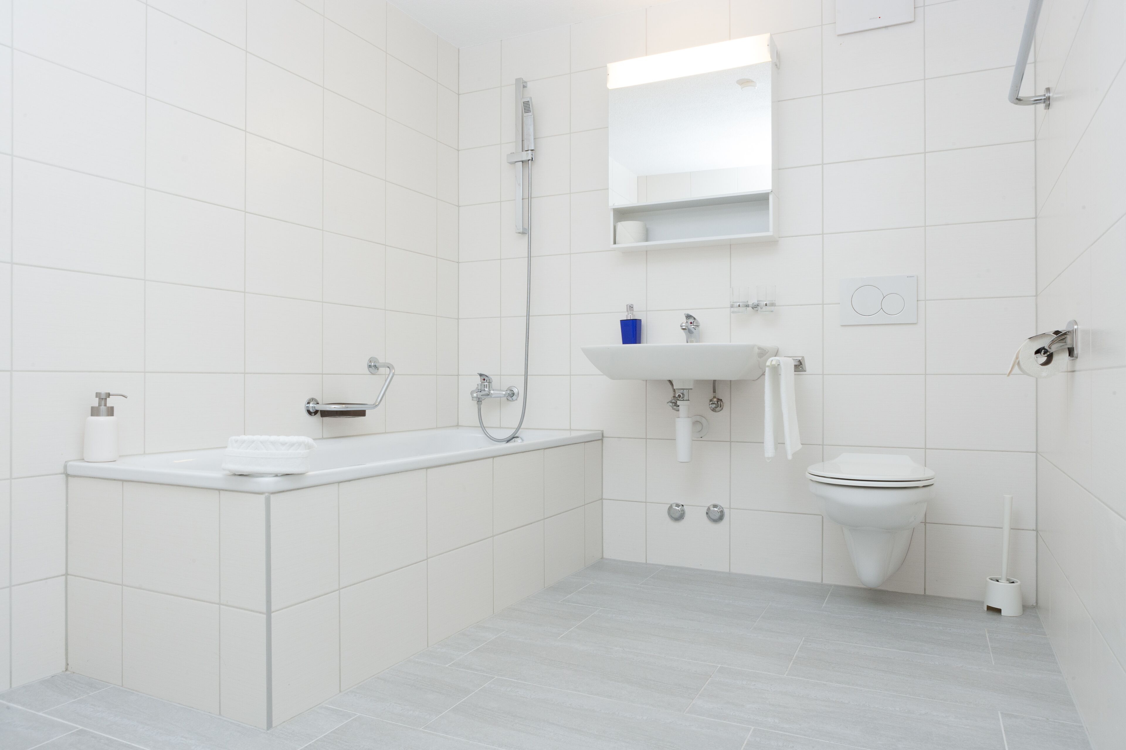 A modern bathroom with a bathtub, sink, and toilet.