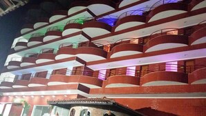 A multi-story hotel with a distinctive architectural design featuring curved balconies and a tiled facade.