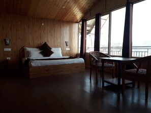 A wooden-paneled room with a bed, a table, and chairs. - Beyond Stay Tikker Narkanda Cottage (Theog)