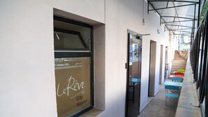 L’entrée d’une auberge de jeunesse, avec une fenêtre sur laquelle est affiché le nom « LeRiv. City Hostel ».