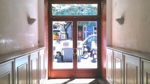 A hallway with a double door leading to an outdoor area.