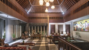 A spacious lobby with a checkered floor, wooden accents, and a high ceiling with hanging lights. - Ayuterra Resort (Ubud)