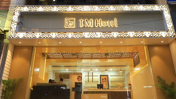 Un hotel con fachada moderna, varios pisos y señalización iluminada.
