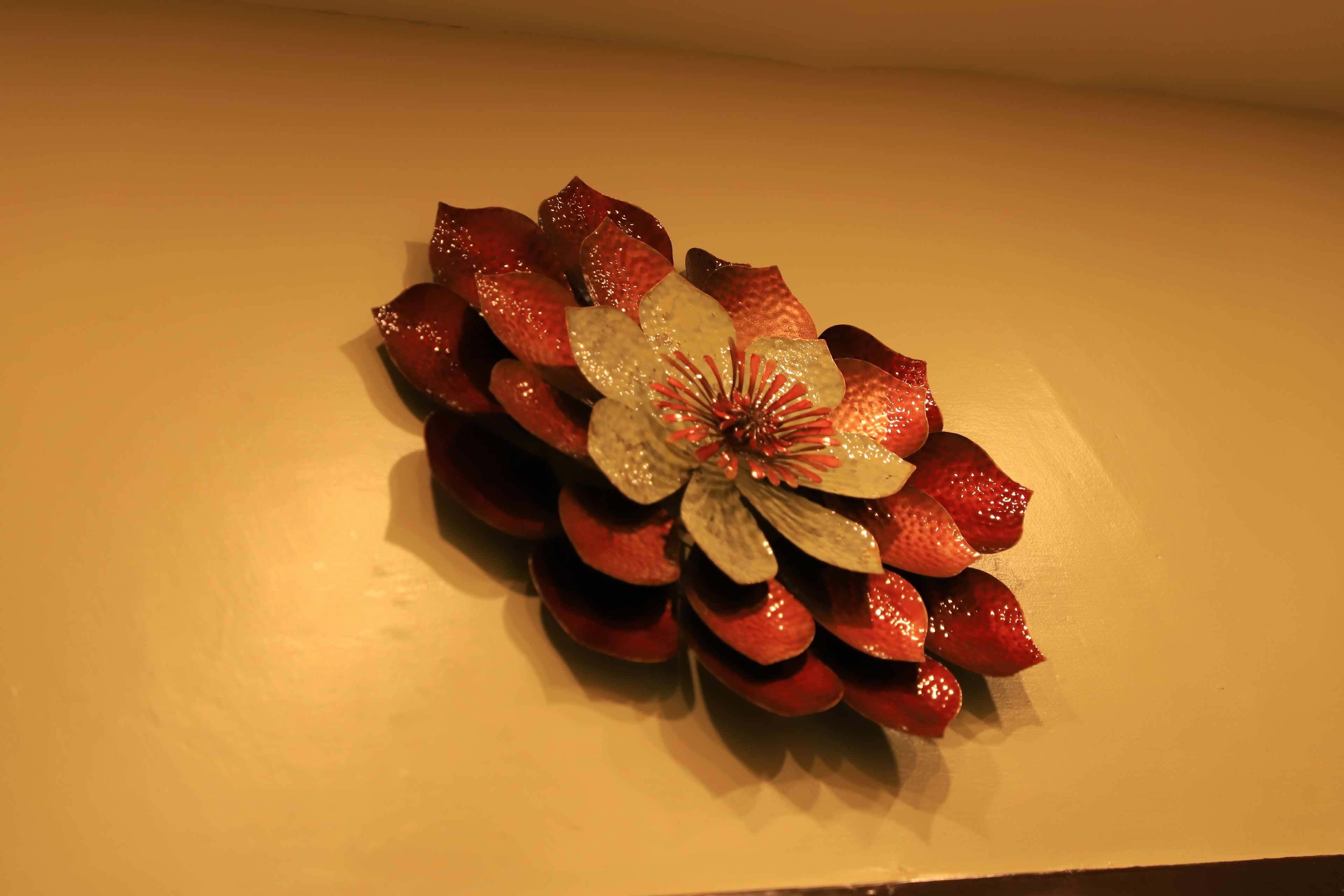 A decorative arrangement of red and white flowers on a wall.