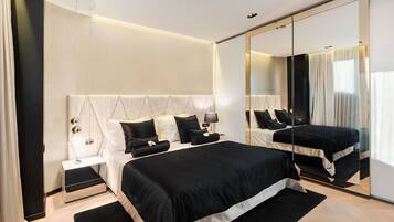 A modern bedroom with a large bed, a bedside table, a mirror, and a nightstand.