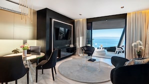 A modern living room with a large TV, comfortable seating, a coffee table, and a view of the sea. - Posh Residence Luxury Suites (Split)