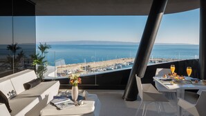 A modern outdoor dining area with a view of the sea and boats. - Posh Residence Luxury Suites (Split)