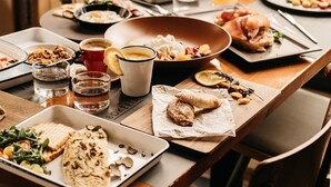 A dining table with various dishes, glasses, and a coffee cup. - Central Square Heritage Hotel (Split)