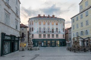 Um edifício histórico com várias lojas, incluindo uma loja 'Weekend' visível.
