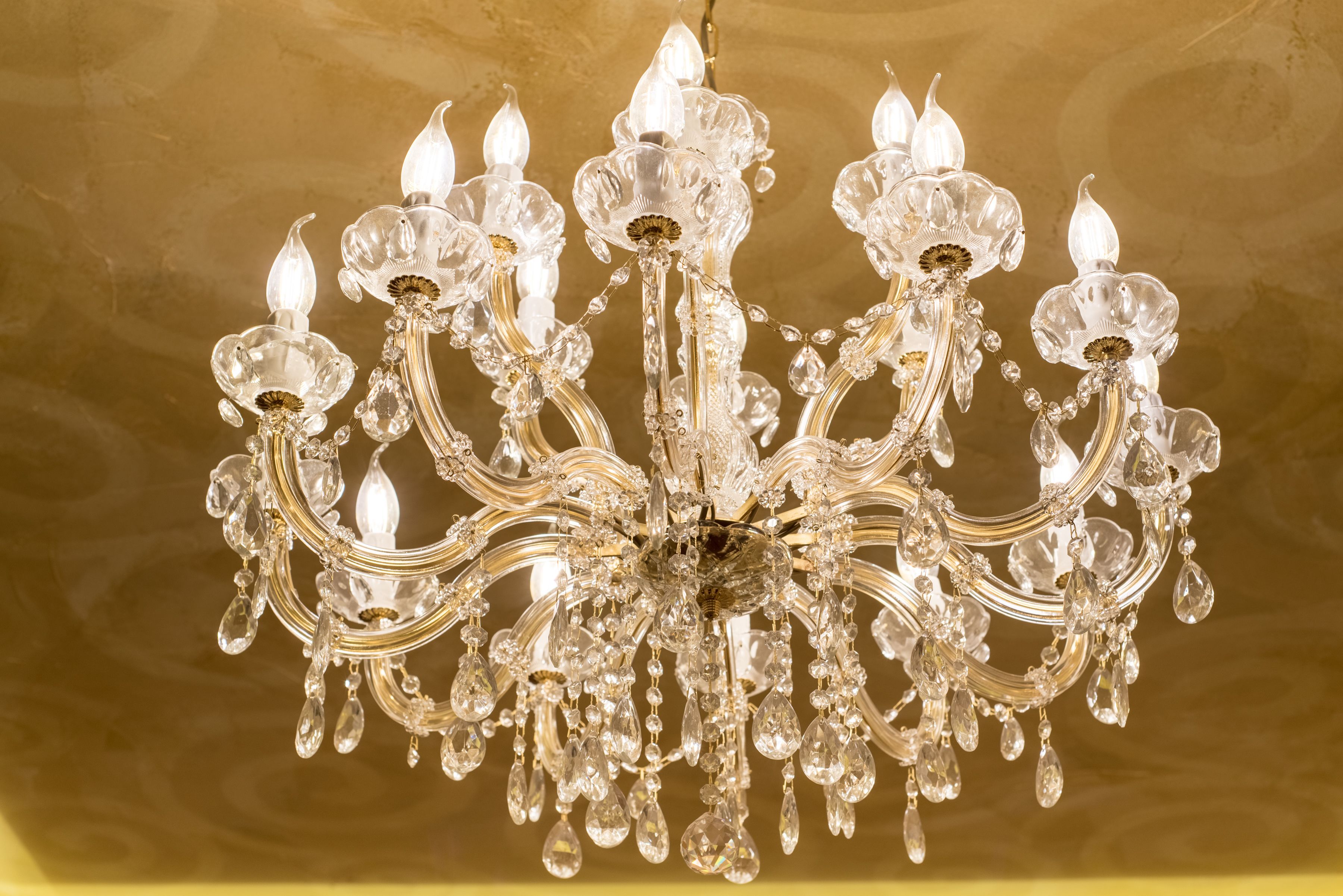 Un lustre à plusieurs bras, orné de décorations en cristal.