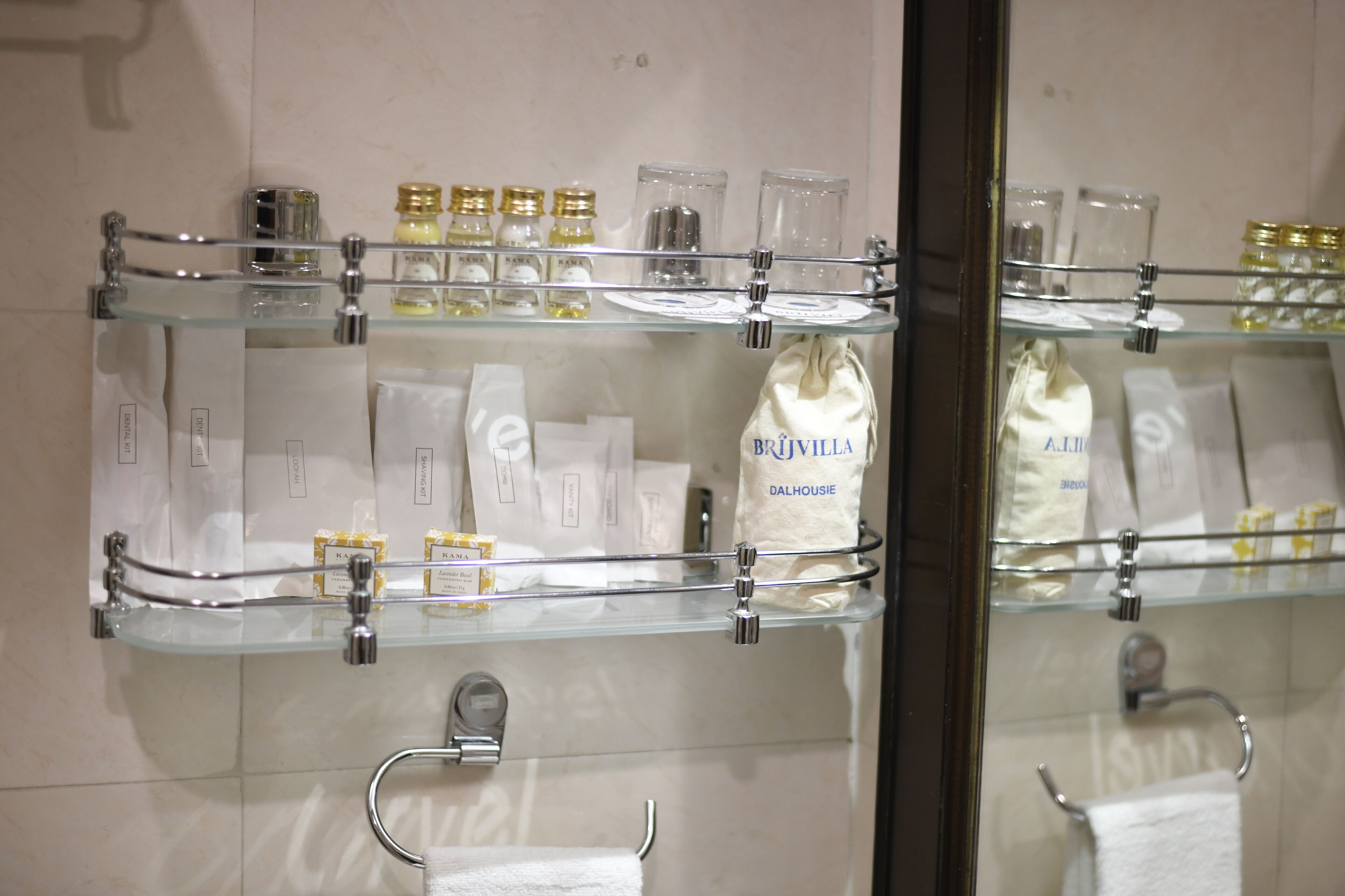 Un baño con varios estantes que exhiben artículos de tocador y un perchero para toallas.