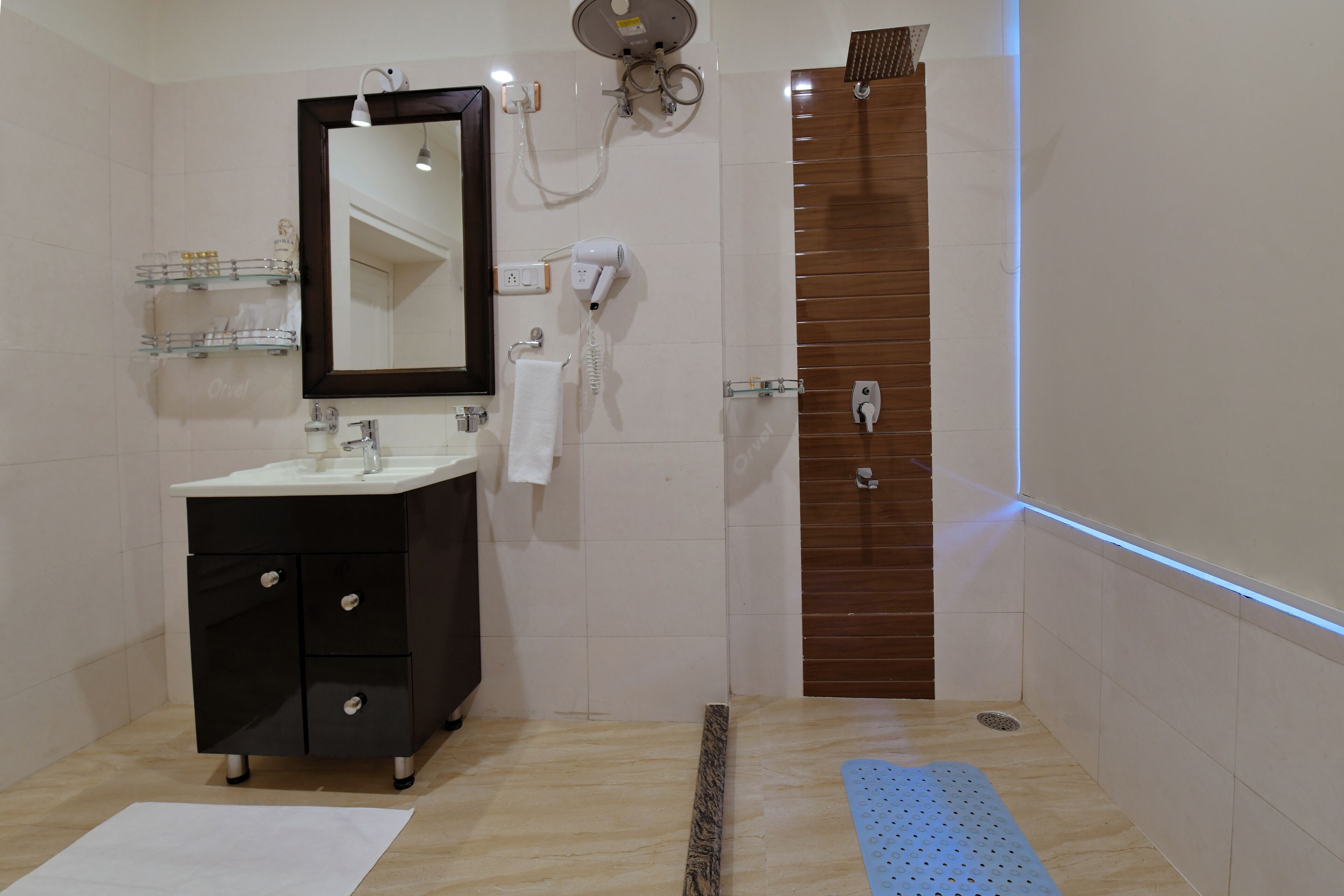 A modern bathroom with a black vanity, a mirror, a towel rack, and a shower area.