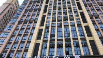 A tall building with a grid of windows and a sign that reads "POLITON INTERNATIONAL SERVICE APARTMENT".