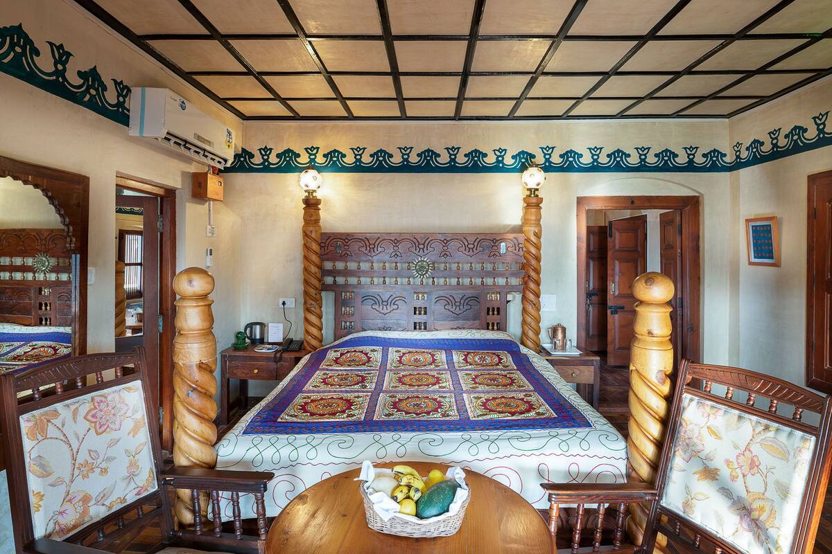 A traditional bedroom with a large bed, ornate headboard, and a decorative ceiling.
