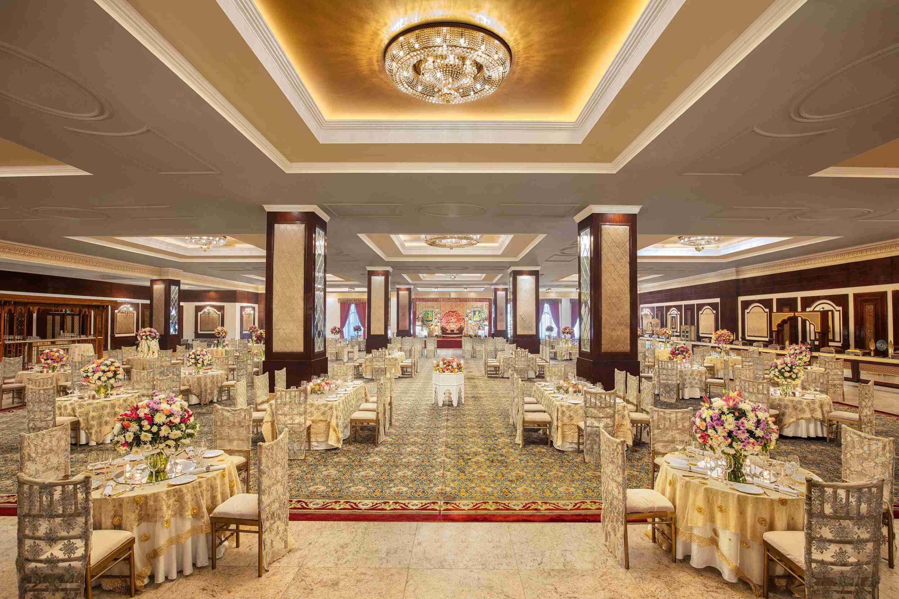 A banquet hall with round tables, chairs, and a central aisle.