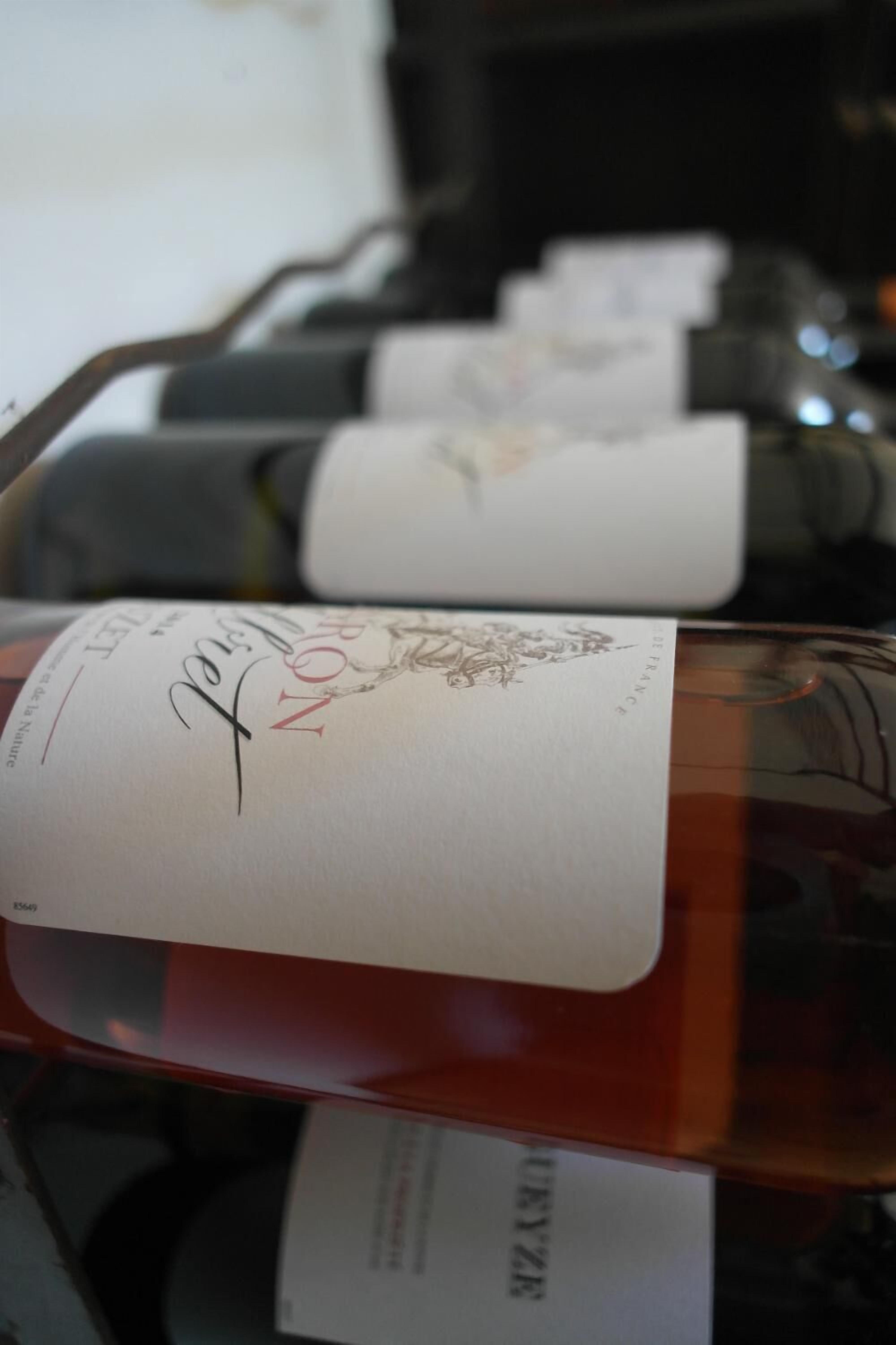 Una botellera con botellas etiquetadas como “Nouveau” y “Noble”.