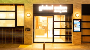 L’entrée d’un bâtiment, avec une enseigne indiquant « cafétéria internationale ».