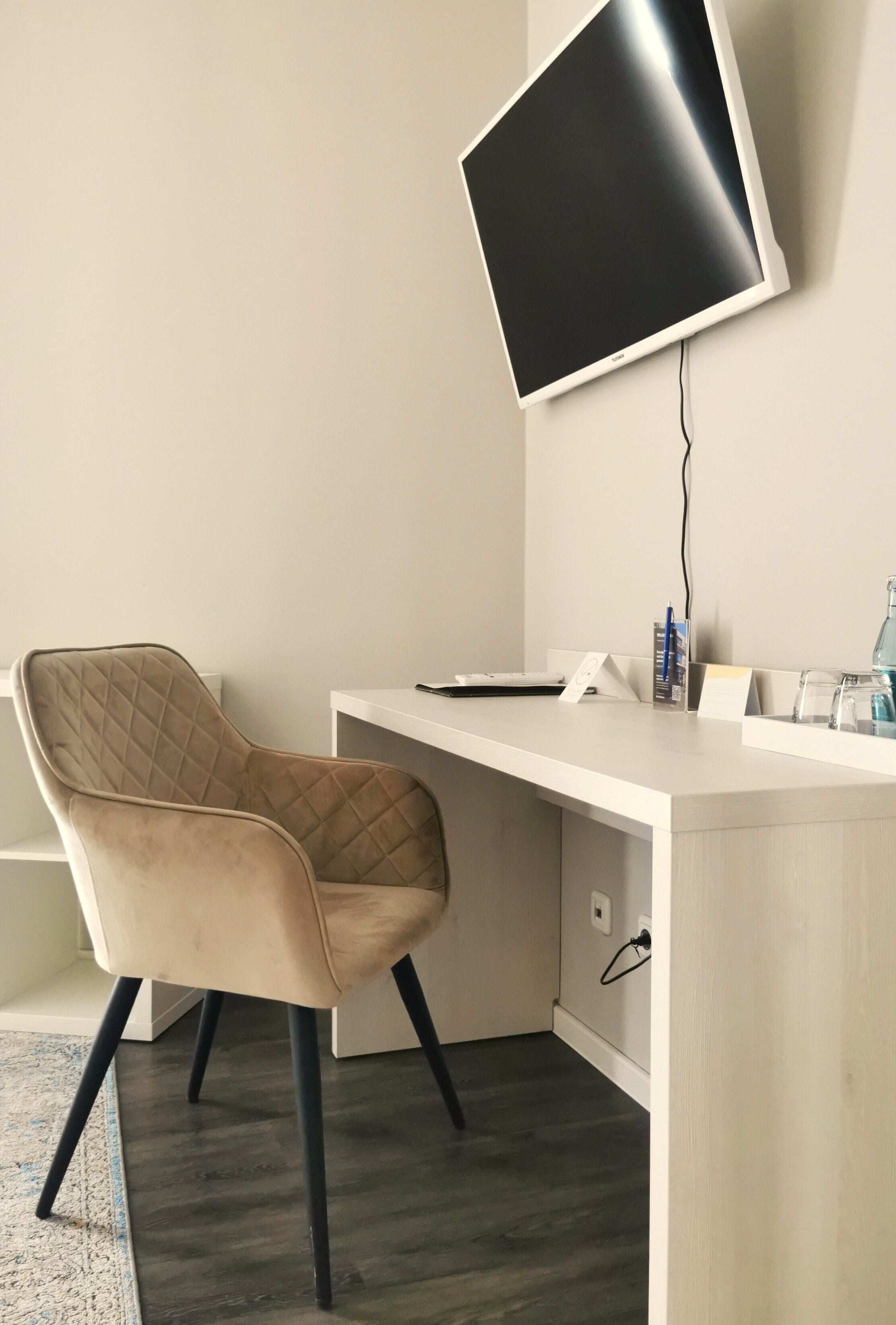 Ein moderner Arbeitsplatz mit einem Drehstuhl, einem Flachbildschirm und einem Schreibtisch.