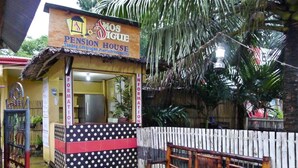 A small, single-story building with a sign reading "Mosigue Pension House" in a tropical setting. - Amos Digue Pension House (Puerto Princesa)