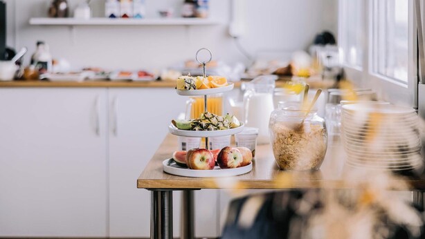 A breakfast buffet with a variety of fruits and cereals on a wooden table. - Hlíð Bed and Breakfast (Myvatn)