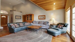 A spacious living room with a sectional sofa, a wooden coffee table, and a blue armchair. - 6 Mt. Hood-Sunriver, Oregon: Hot Tub, BBQ, WiFi, SHARC Aquatics, Tubing Hill, Mt. Bachelor, Golf, Deschutes River, Tennis, Bike Paths (Sunriver)