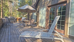 A wooden deck with outdoor furniture, including a table, chairs, and a lounge chair. - 6 Mt. Hood-Sunriver, Oregon: Hot Tub, BBQ, WiFi, SHARC Aquatics, Tubing Hill, Mt. Bachelor, Golf, Deschutes River, Tennis, Bike Paths (Sunriver)