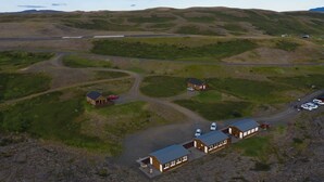 An aerial view of a rural property with several buildings, roads, and vehicles. - Hlíd Hostel (Myvatn)