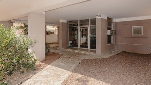 A building entrance with a tiled patio, a glass door, and a small garden area with plants. - 2Rooms Perfect Location  1Min to  Beach (Tel Aviv)