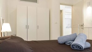 A hotel room with a bed, a wardrobe, and a bathroom visible through an open door. - 2Rooms Perfect Location  1Min to  Beach (Tel Aviv)