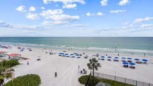 A beach with umbrellas and people.