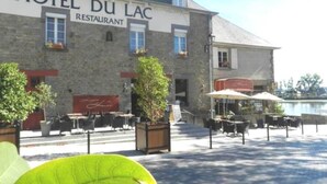 A building labeled "HOTEL DU LAC RESTAURANT" with outdoor seating and potted plants. - Hotel Restaurant du Lac (Boe)