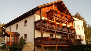 A traditional wooden building with multiple balconies, a stone foundation, and a sign indicating it is a hotel. - Ferienhaus Haidweg (Haidmuhle)