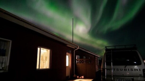 A building with a Mitsubishi van parked in front, a window, and a door. - Eldá Guesthouse (Myvatn)