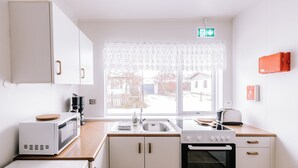 Cozinha compacta com micro-ondas, torradeira, pia e forno.