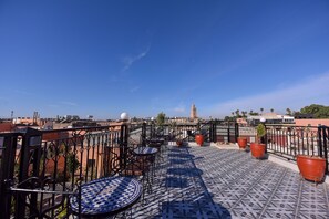 A rooftop terrace with tiled flooring, outdoor furniture, and potted plants. - Riad Assia (Marrakech)