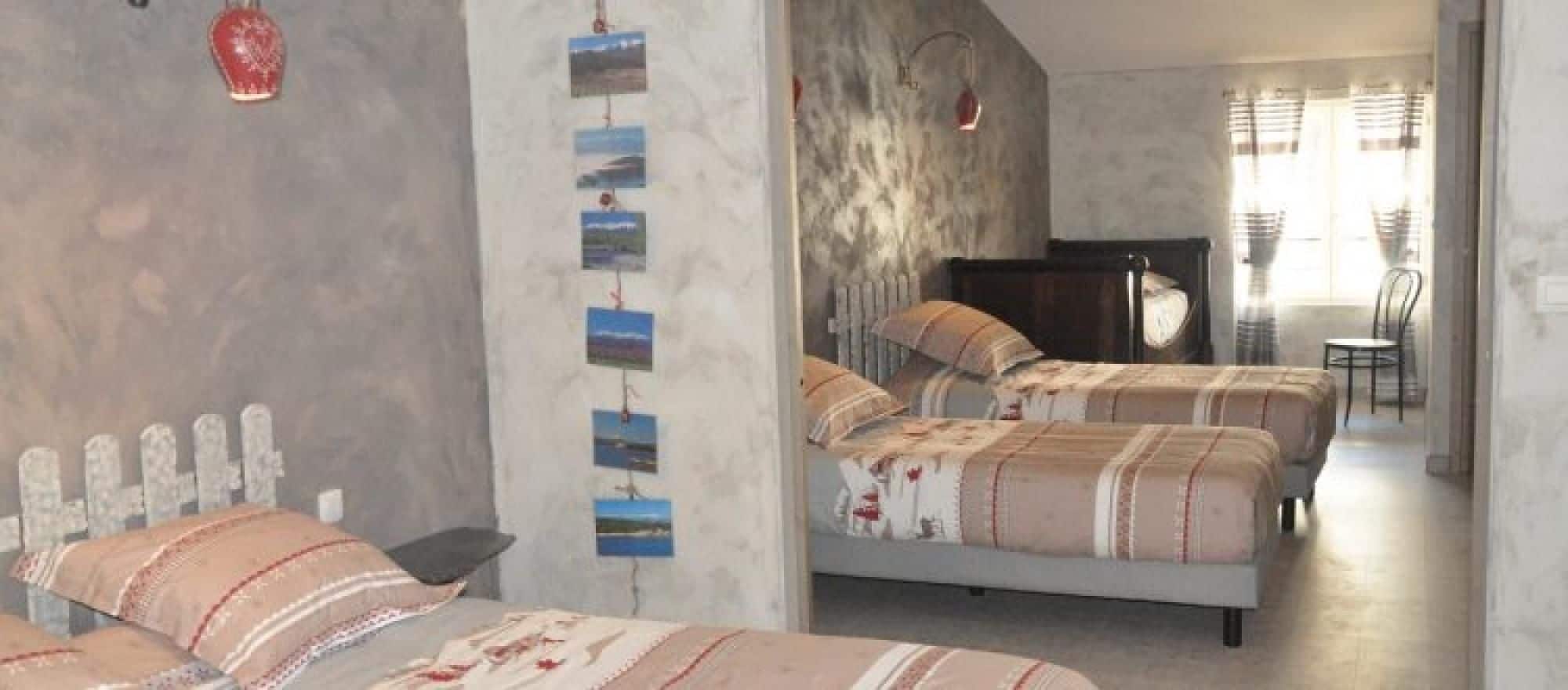 Ein Hotelzimmer mit zwei Betten, einem kleinen Tisch und einer Wand mit Bildern.