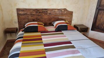 Un lit avec une couvre-lit à rayures, deux oreillers et deux tables de chevet avec des lampes.